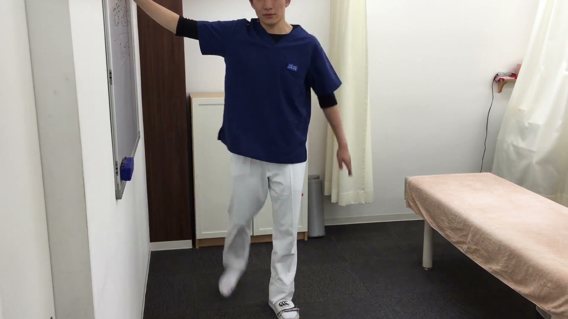 壁につかまり脚を前後に大きく振るダイナミックストレッチ