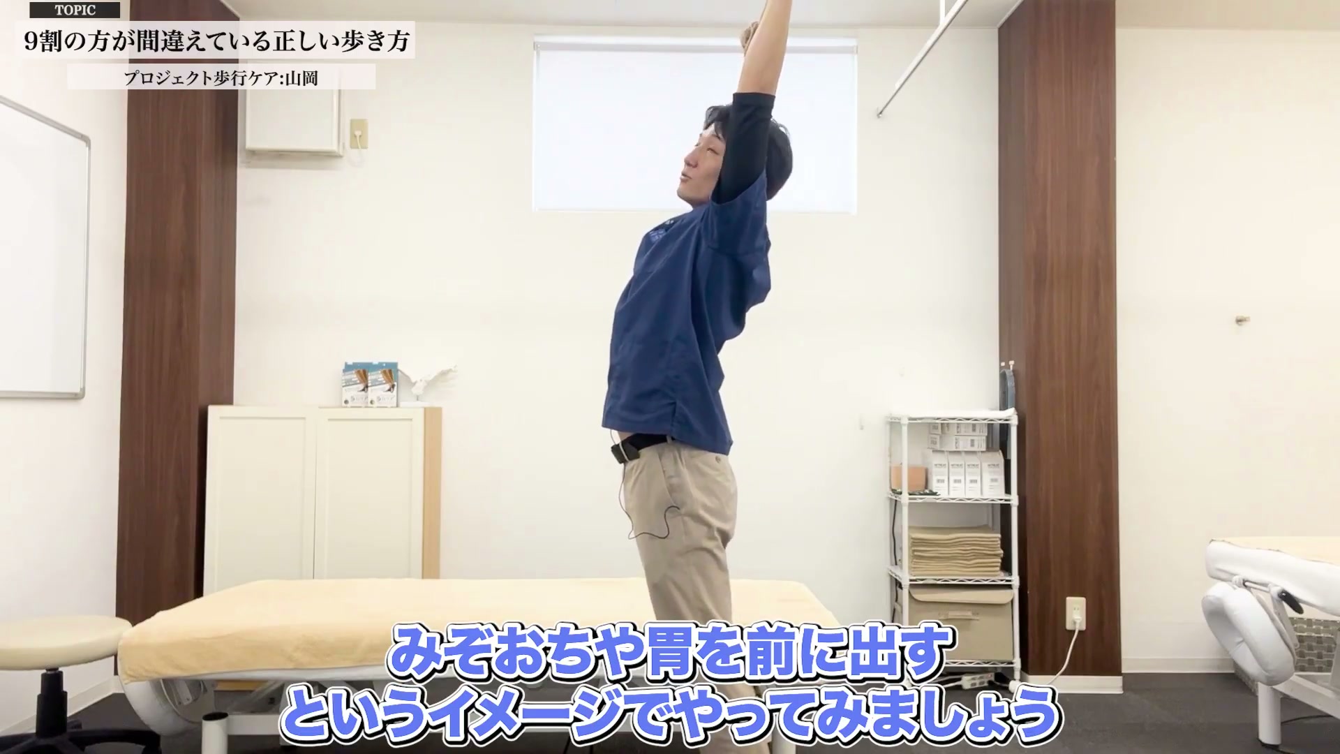 タオルを持って腕を上げ体幹を伸ばすストレッチ